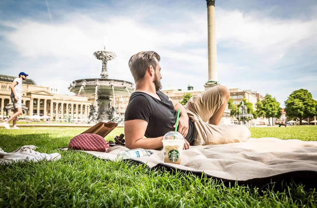 Am Stuttgarter Schlossplatz lässt es sich mit einer Decke auf der Wiese herrlich faulenzen.