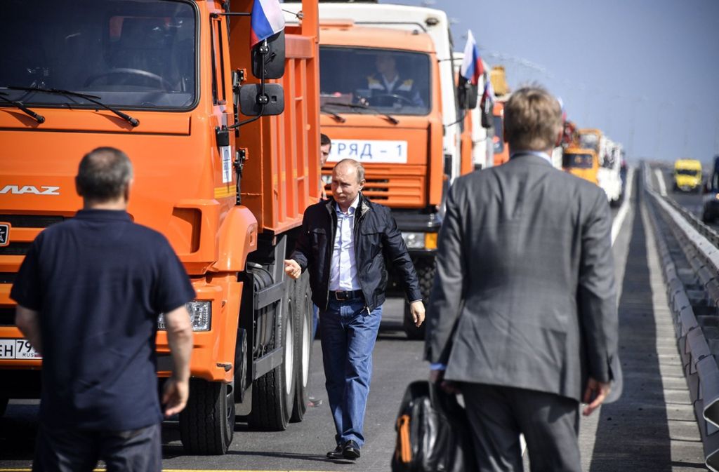 Wladimir Putin besteigt den ersten LKW in einem Tross von Baumaschinen. Für den russischen Präsidenten eine gute Gelegenheit, sich als Macher feiern zu lassen.