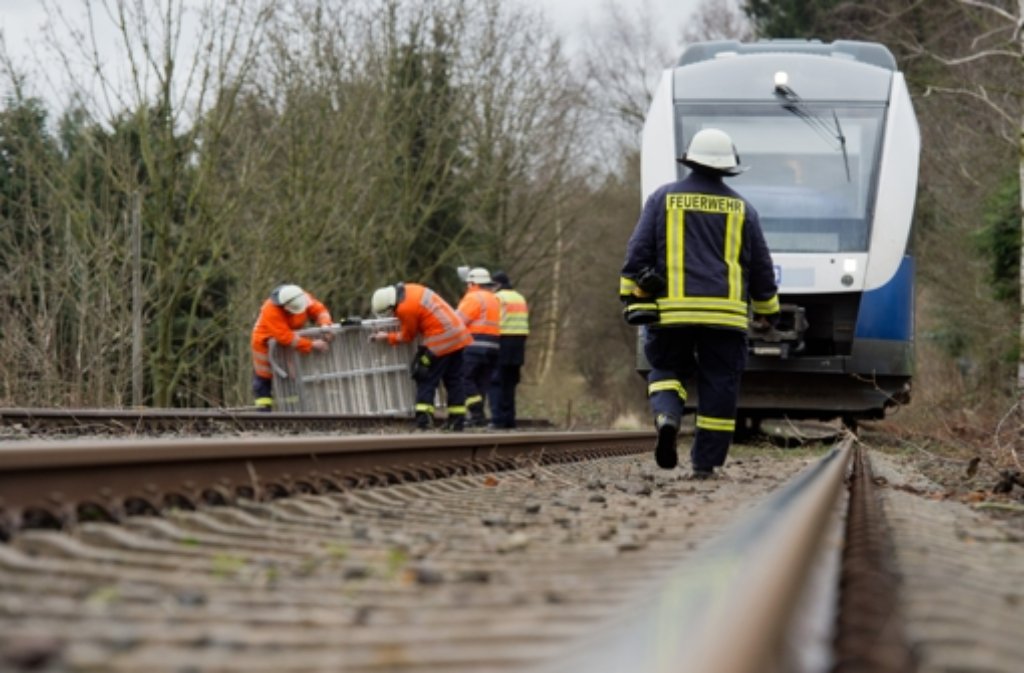 Einsatzkräfte von Bundespolizei und Feuerwehr stehen vor einem Regionalzug der Nordwestbahn in Coppenbrügge im Landkreis Hameln (Niedersachsen), nachdem dieser mit umgestürzten Bäumen kollidiert war.