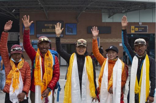 Tsang Yin-hung (Mitte) aus Hongkong winkt den Journalisten während einer Pressekonferenz anlässlich ihres aufgestellten Rekordes für den Aufstieg des Mount Everest. Die Lehrerin Tsang Yin-hung brauchte für den Weg vom Basislager des Mount Everests bis zur 8848,86 Meter hohen Spitze 25 Stunden und 50 Minuten. Foto: Foto: Bikram Rai/AP/dpa