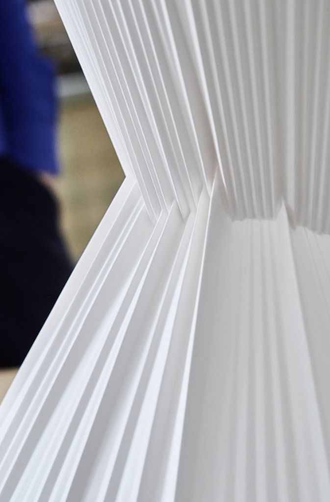Der Tisch ist das Ergebnis von technisch anspruchsvoller Experimentierlust: „Wir wollten die Feinheit und Weichheit des Materials Porzellan zeigen und sind daher auf Textilien und Plissee gekommen“, sagt Marcel Besau zur Idee, den Tisch in Falten zu legen.