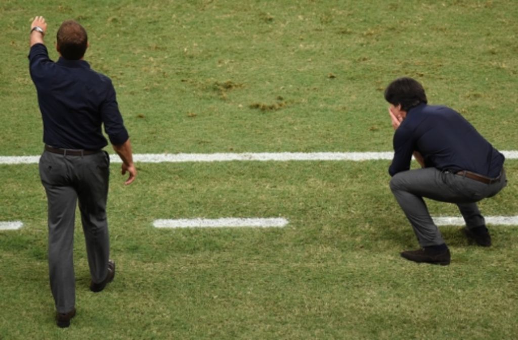 Die Leiden des Bundestrainers: während Joachim Löw vor Ärger in die Knie geht, gibt sein Assistent Hansi Flick Anweisungen.