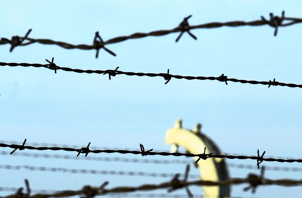 Blick durch den Stacheldrahtzaun ins KZ Auschwitz-Birkenau