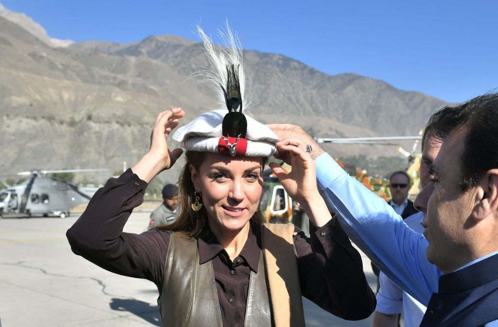 Bei ihrer Ankunft in einem Dorf im Chitral-Tal bekommt die Herzogin von Cambridge erst einmal einen traditionellen Hut aufgesetzt.