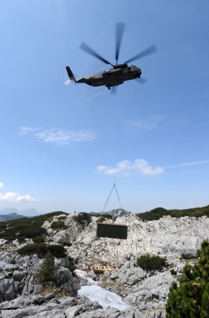 Ein Helikopter der Bundeswehr liefert einen Container zum Eingang der Riesending-Schachthöhle.