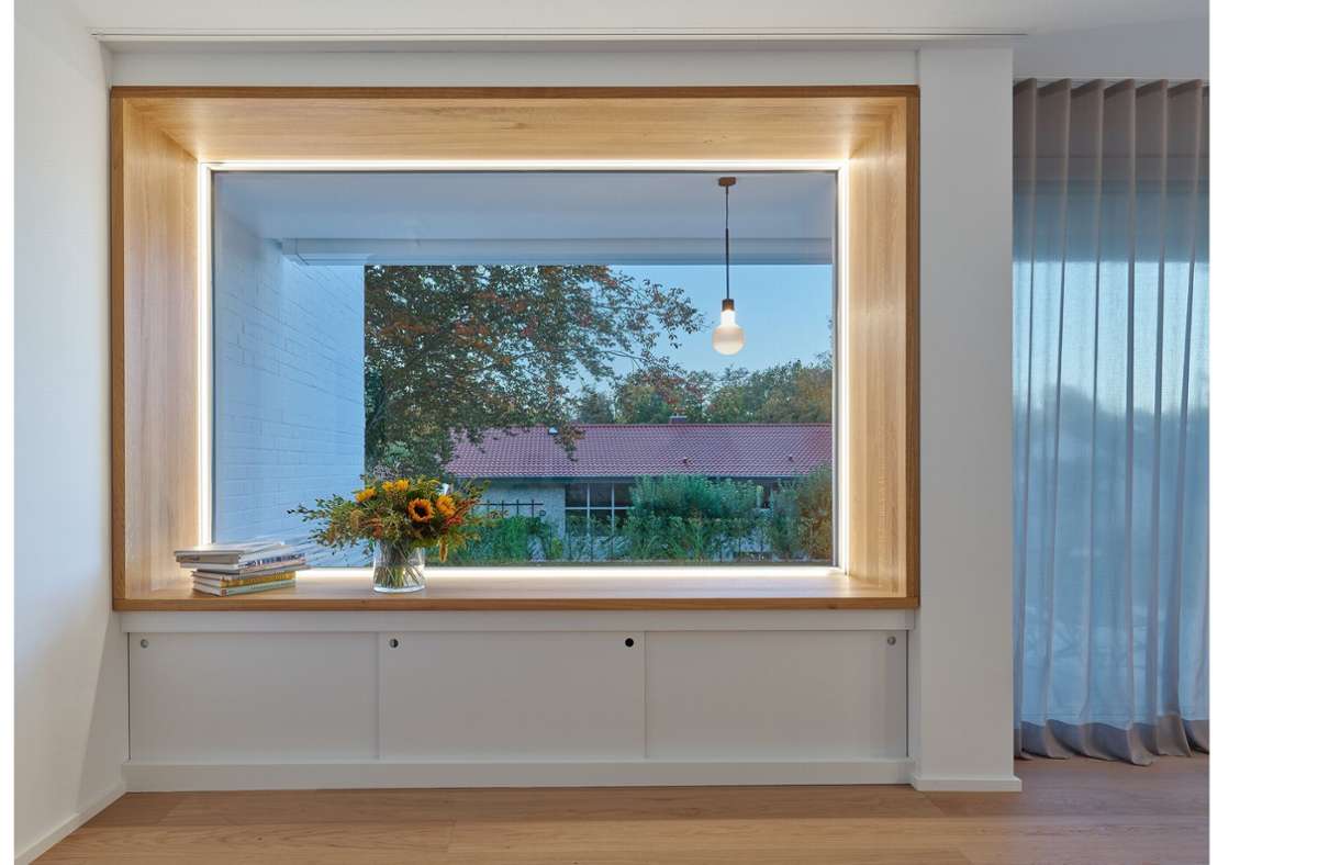 Im Wohnzimmerbereich beeindruckt ein großes Fenster mit Stauraum unter der schönen Sitznische, diese ermöglicht einen Blick in den Garten.