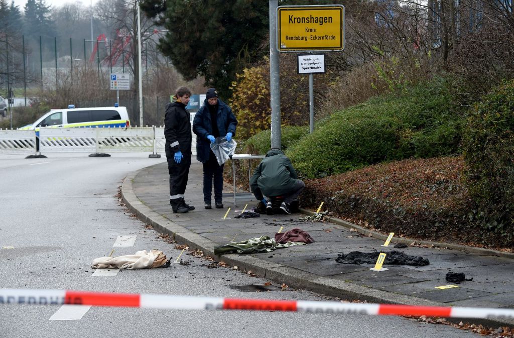 Kriminalbeamte sichern in Kronshagen bei Kiel (Schleswig-Holstein) am Tatort verbrannte Kleidungsstücke.