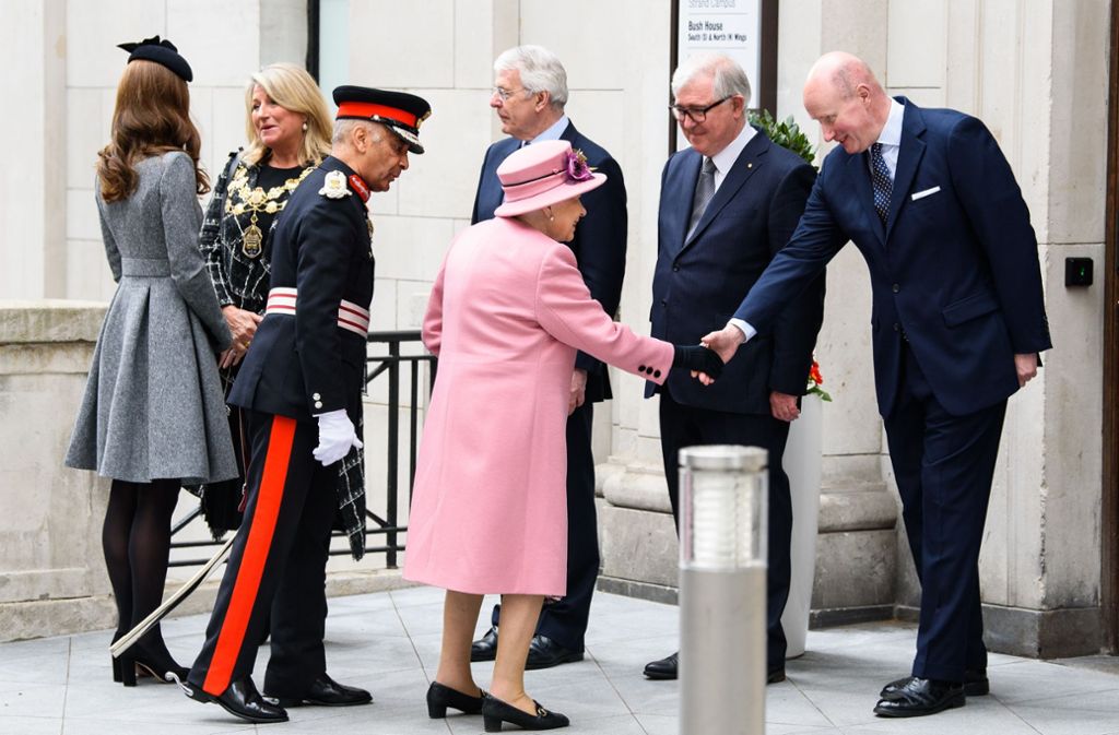 Die Queen scheint indes bestens gelaunt und strahlt in einem rosa Kostüm mit Perlenkette. Kate trägt ein graues Kleid von Catherine Walker.