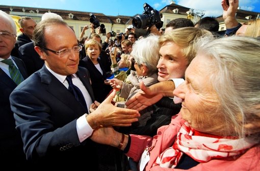 Händeschütteln im Schlosshof: Hollande und Merkel geben sich bürgernah. Foto: DPA