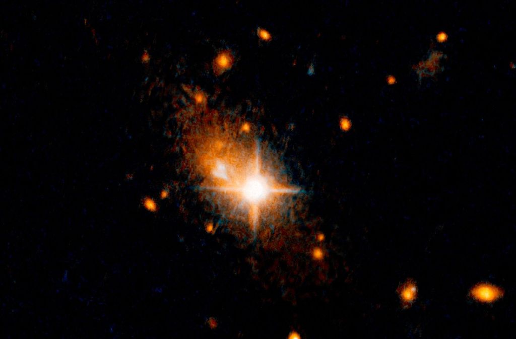 Der helle, sternenähnliche Quasar (Bildmitte), der der aktive Kern einer Galaxie ist, ist vor seiner Heimatgalaxie zu sehen. Ein gigantischer Gravitationswellen-Tsunami hat ein supermassereiches Schwarzes Loch aus dem Herz seiner Heimatgalaxie geschleudert.