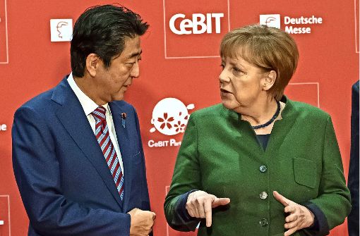 Bundeskanzlerin Angela Merkel und  der japanische  Ministerpräsident Shinzo Abe sprechen  vor der Eröffnung der  Cebit – Japan ist diesmal Partnerland. Foto: dpa