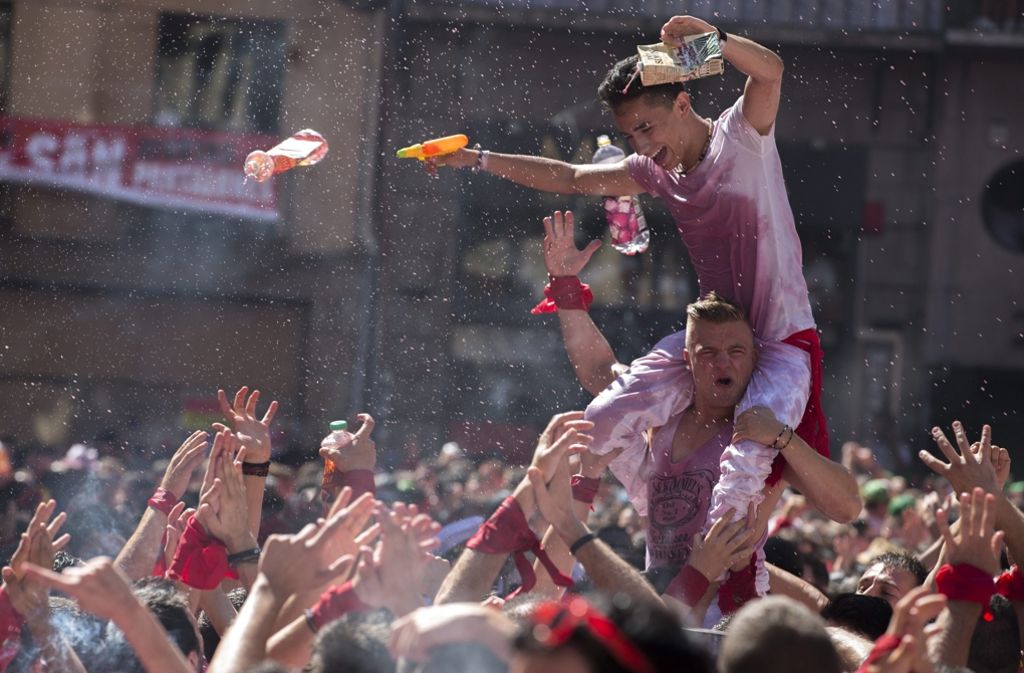 In den Straßen von Pamplona feiern Einheimische und Touristen eine feuchtfröhliche Party.