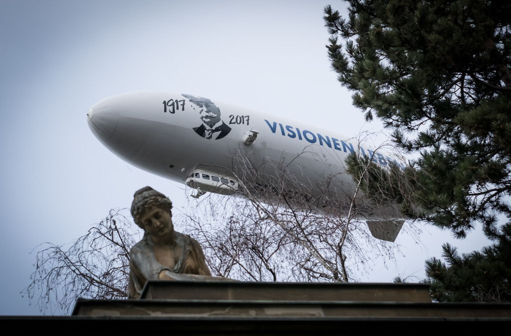 Das Luftschiff mit der Inschrift „Visionen leben“ und einem Porträt des Grafen und seinen Lebensdaten fliegt über den Pragfriedhof.