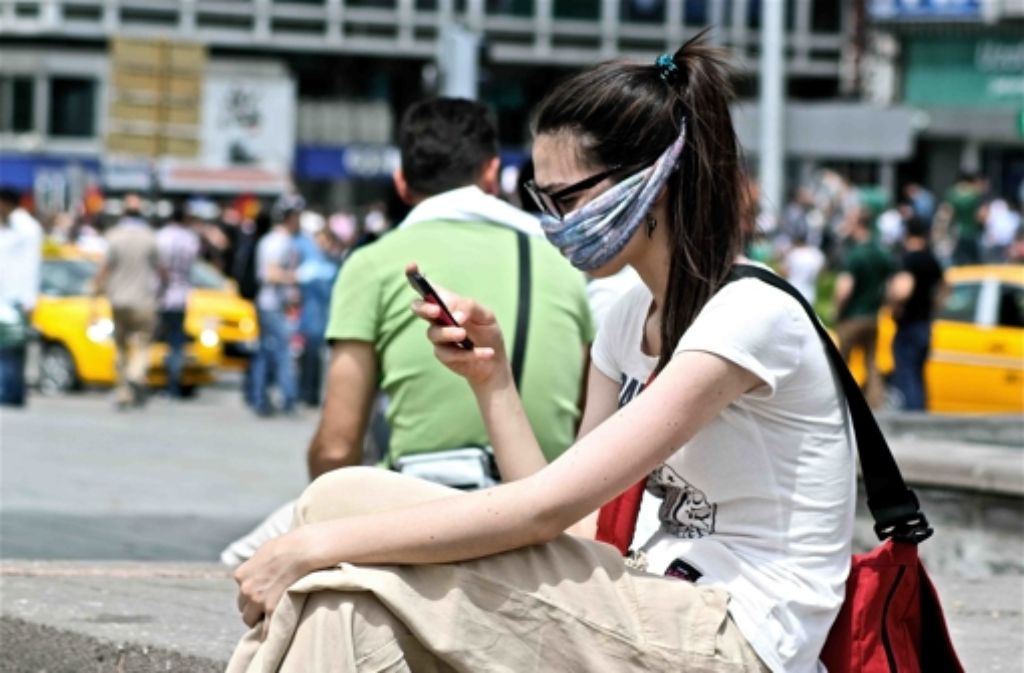 Eine Pause am Rande der Kundgebung: Eine Demonstrantin schaut auf ihr Smartphone am zentralen Güven-Park in Ankara.