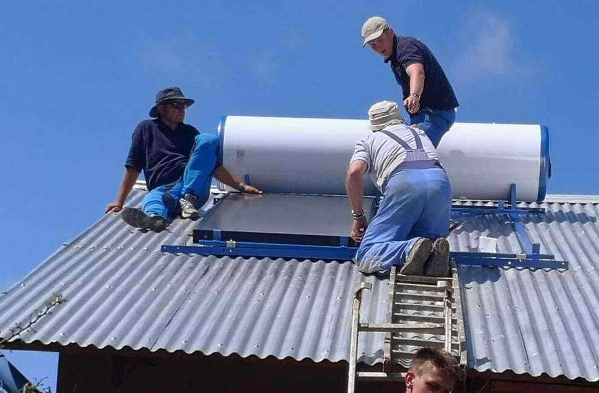 Das deutsche Team installiert die Solaranlage auf dem Schulhausdach. Sie liefert Warmwasser für Duschen und Küche.