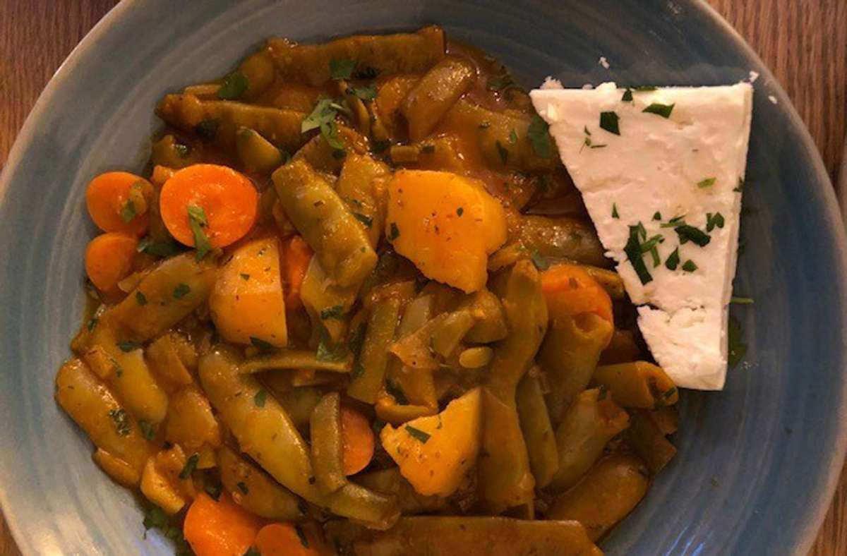 Wirkt wie aus Omas Rezeptesammlung: Fasolakia, ein Eintopf mit breiten, grünen Bohnen, Kartoffeln, Karotte und einem Stück Feta.