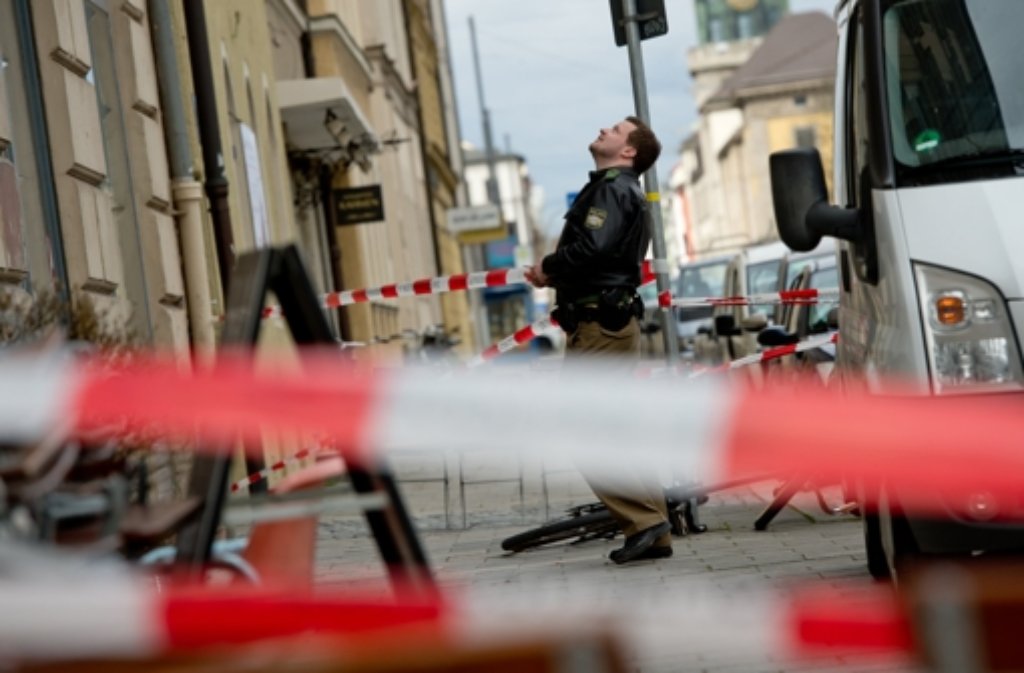 Ein Polizist sperrt in München (Bayern) einen Gehweg ab, weil dort zuvor Dachziegel von einem Haus heruntergefallen sind.