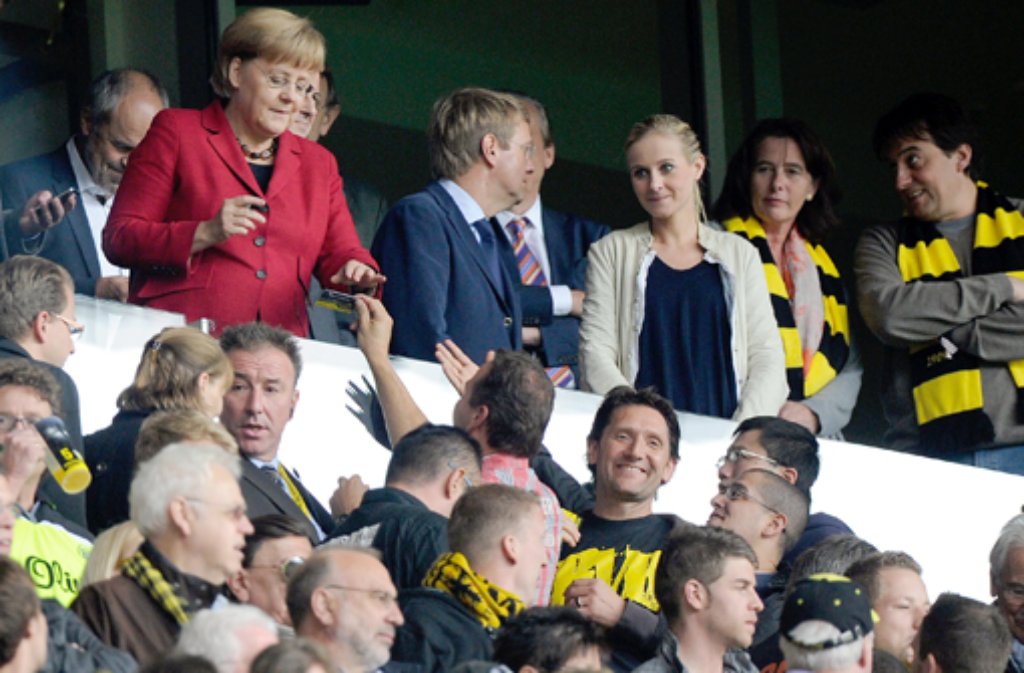 ... kommt Angela Merkel (links oben) - wenn es um Fußball geht - häufig so richtig aus sich heraus. Lassen Sie sich von dem Foto nicht täuschen: Die Kanzlerin ist kein BVB-Fan. Sie drückt ...