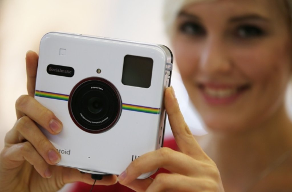 Diese Frau schaut sich die Polaroid Kamera Socialmatic an. Dabei handelt es sich um eine neue Sofortbildkamera mit integriertem ZINK-Drucker und digitaler Anbindung an soziale Netzwerke wie Facebook oder Twitter.