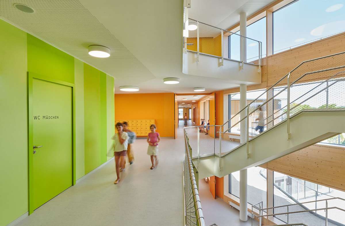 Das atriumartige Treppenhaus fungiert als Verteiler – von hier geht es in die unterschiedlichen Schul-Zonen mit ihren farbig markierten Lernhäusern.