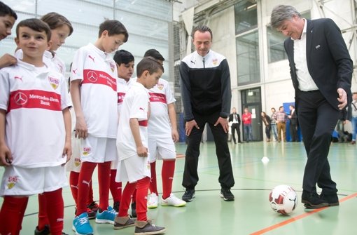 Günther Schäfer (Mitte) und Bernd Wahler vom VfB Stuttgart kicken mit Flüchtlingen.  Foto: dpa