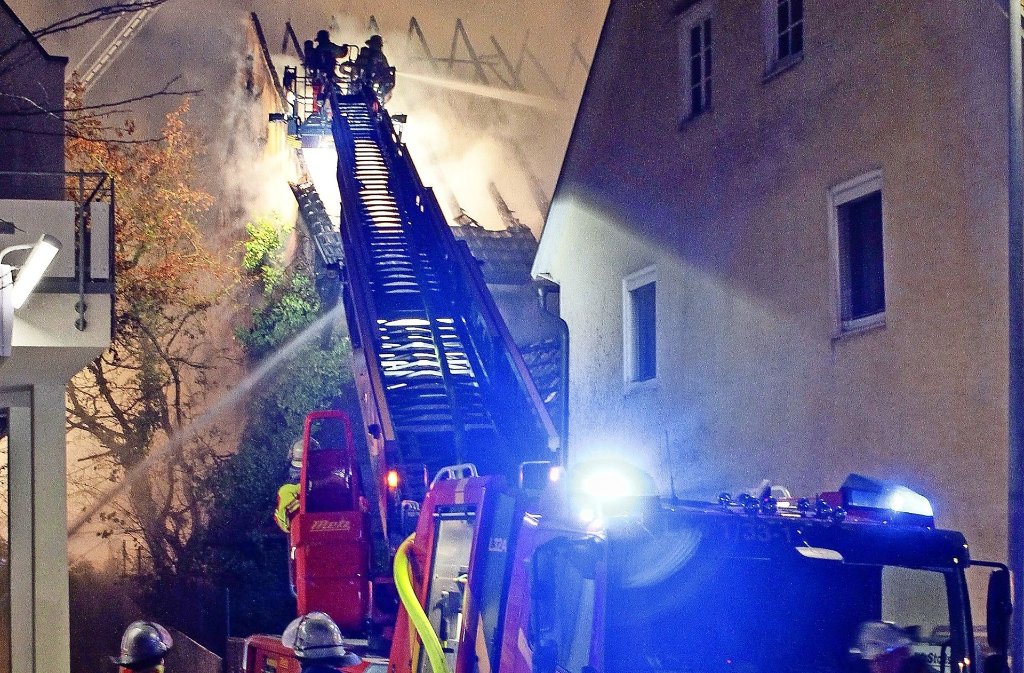Mit einem Wasserriegel schirmen die Feuerwehrleute die brennende Scheune von den Nachbargebäuden ab. So wird ein Übergreifen der Flammen verhindert.