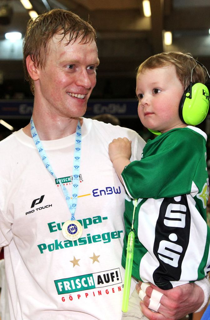 Christian Schöne, der heutige Sportliche Leiter, feiert mit einem seiner beiden Söhne auf dem Arm.