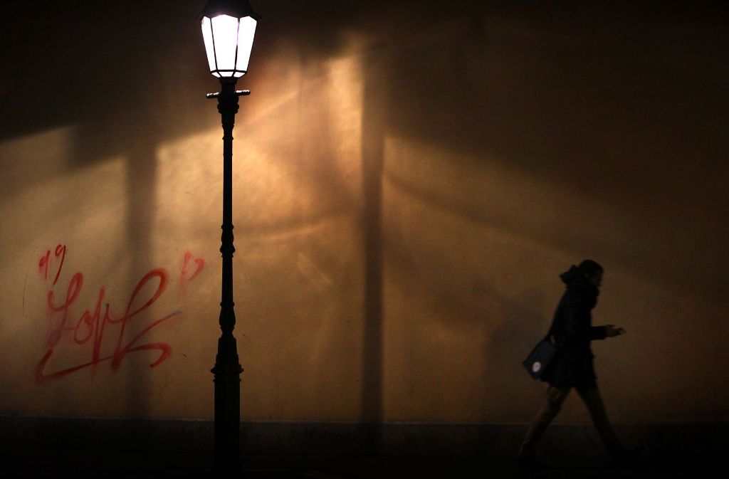 Eine Frau läuft nachts durch eine spärlich beleuchtete Straße. Eine Situation, in der die Angst vor dem Unbekannten durchaus berechtigt ist.