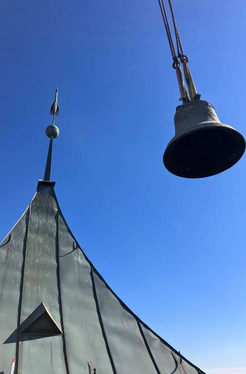 Die Glocke im Anflug neben dem Turmdach der Fellbacher Pauluskirche