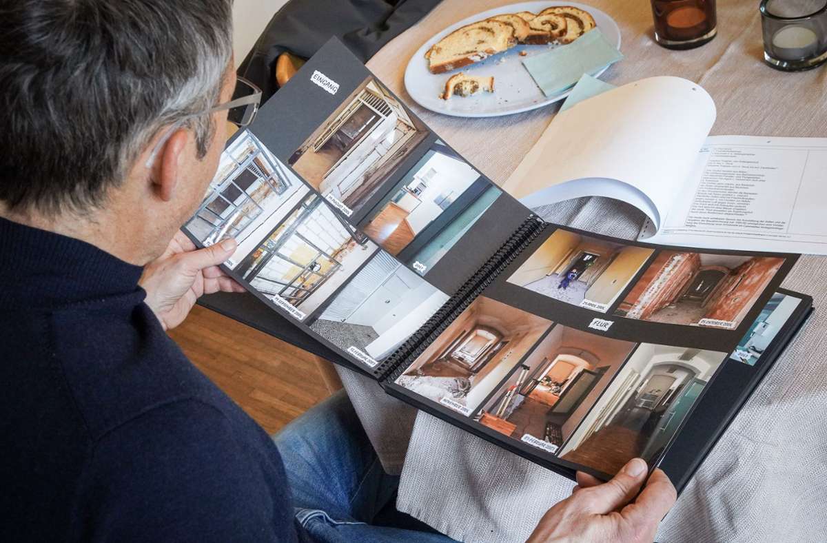 Andreas Wolf blättert in einem Fotoalbum, die das Haus im Jahr 2006 zeigen, als die Käufer es das erste Mal sahen.