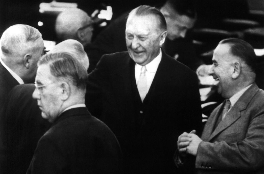 Bundeskanzler Konrad Adenauer (Mitte) nimmt nach seiner erneuten Wahl zum Bundeskanzler am 22. Oktober 1957 im Bonner Bundestag die Glückwünsche seiner Parteifreunde entgegen. Links der CDU-Fraktionsvorsitzende Heinrich Krone, ganz rechts der Abgeordnete Eugen Huth.