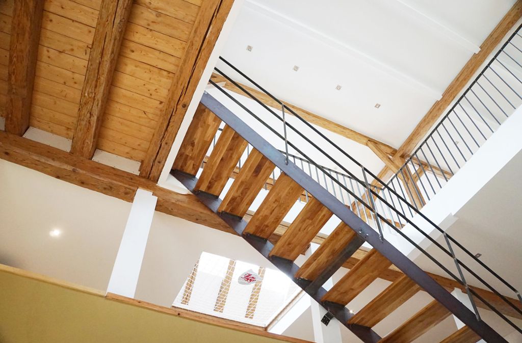 Treppenaufgänge aus Holz, schmiedeeiserne Geländer: Die Aufteilung des kompletten Raumes bleibt luftig, offen und ist betont kommunikativ.