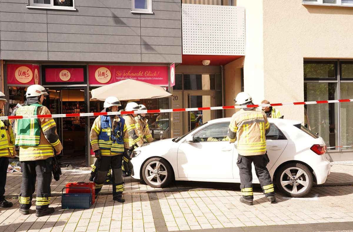 Feuerwehrleute schieben den Audi weg.