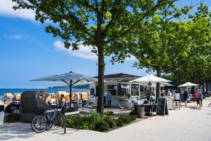 Ein Bistro an der Strandpromenade der Kieler Förde. Wer bekommt da nicht Lust sein Fahrrad für eine Pause zu parken und sich einen kühlen Drink zu gönnen?