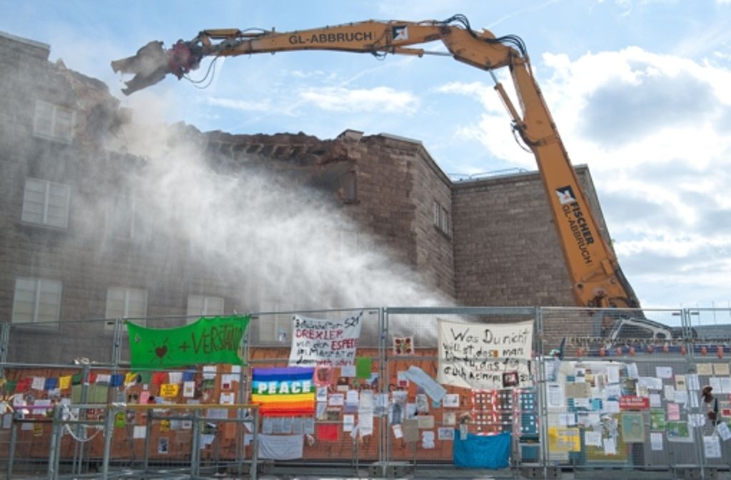Am 25. August 2010 begann ein Abrissbagger mit den Arbeiten. Davor: der Bauzaun mit Protestplakaten.