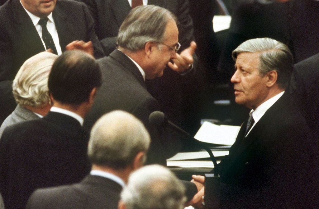 Der gestürzte Bundeskanzler Helmut Schmidt (rechts, SPD) beglückwünscht am 1. Oktober 1982 seinen Nachfolger Helmut Kohl (Mitte) zu dessen Wahl.