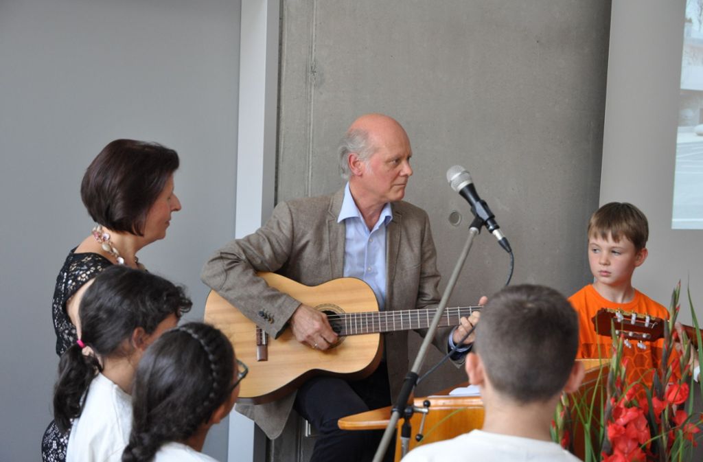 Rektor Reinhold Sterra greift selbst zur Gitarre - für den gemeinsamen Kanon „Lachend kommt der Sommer über das Feld“.