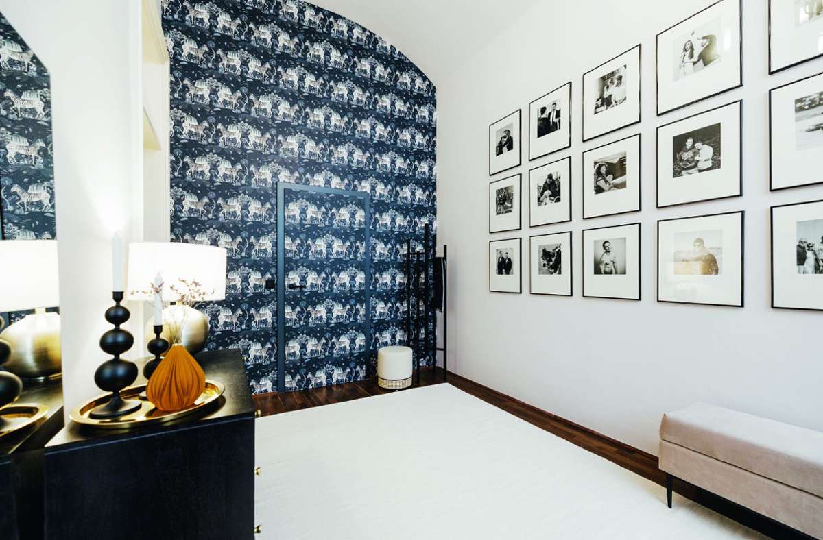 Ein letzter Blick in den Innenarchitekturbildband „Best of Interior 2022“: eine Diele wie ein Galerie-Zimmer mit Tapetentür und geometrisch angeordneten Bildern, gestaltet von Innenarchitektin Yvonne Meindl-Cavar von Schönstil.