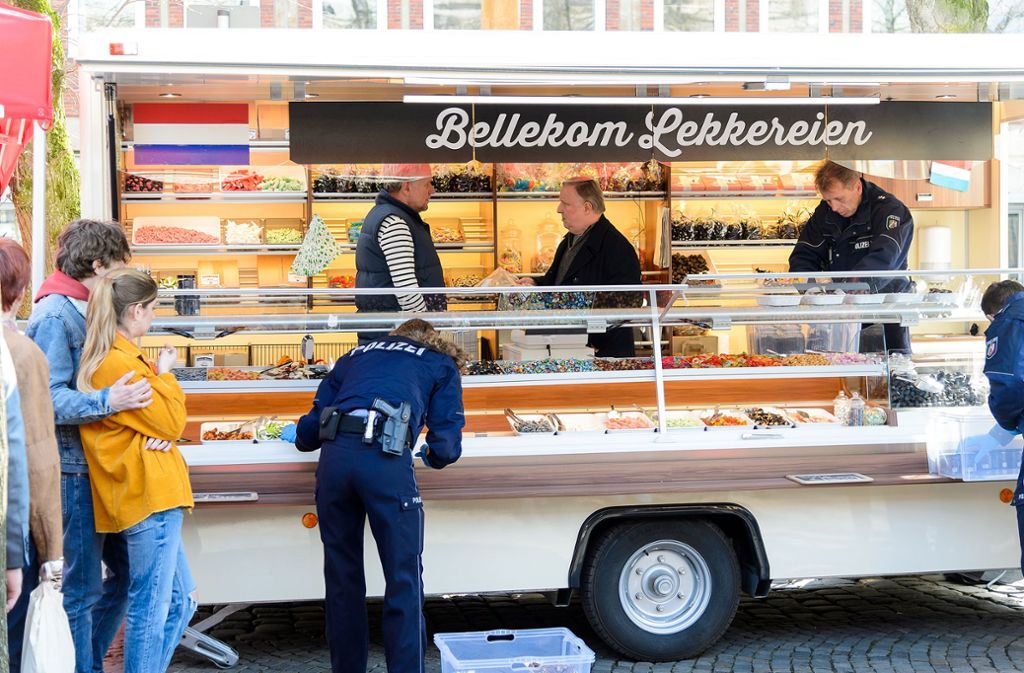 Verkaufs-Stopp! Lakritzhändler Cornelius Bellekom (Ronald Top, links hinten) muss zusehen, wie Kommissar Frank Thiel (Axel Prahl, hinten Mitte) am Marktstand verdächtige Waren sicherstellen lässt.