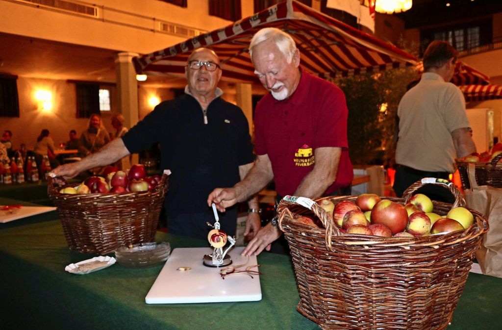 Horst Hoffmann und Johann Pütz demonstrieren den Apfelschäler bei der Sichelhenke in der Festhalle.