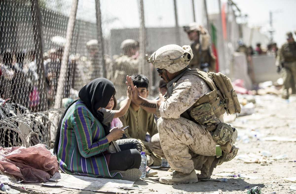 Ein US-Soldat grüßt ein Kind am Flughafen von Kabul. Dort warteten Ende August Tausende darauf, ausgeflogen zu werden. Viele blieben trotz Aufnahmezusage aus Deutschland zurück.