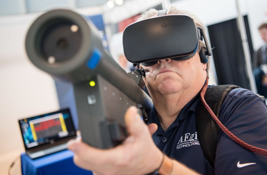 Drinnen ist vom Protest nichts zu spüren. Ein Mitarbeiter testet einen VR-Simulator. VR steht dabei für Virtual Reality.