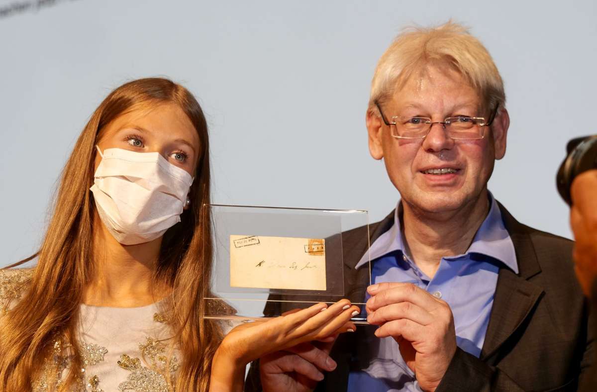 Auktionator Christoph Gärtner mit Tochter Carolin präsentieren die Briefmarke.