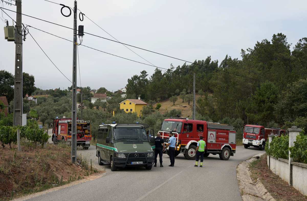 Ein Konvoi von Feuerwehrfahrzeugen fährt an einer Straßensperre der Polizei im Dorf Rebolo in der Nähe von Ansiao in Zentralportugal vorbei.