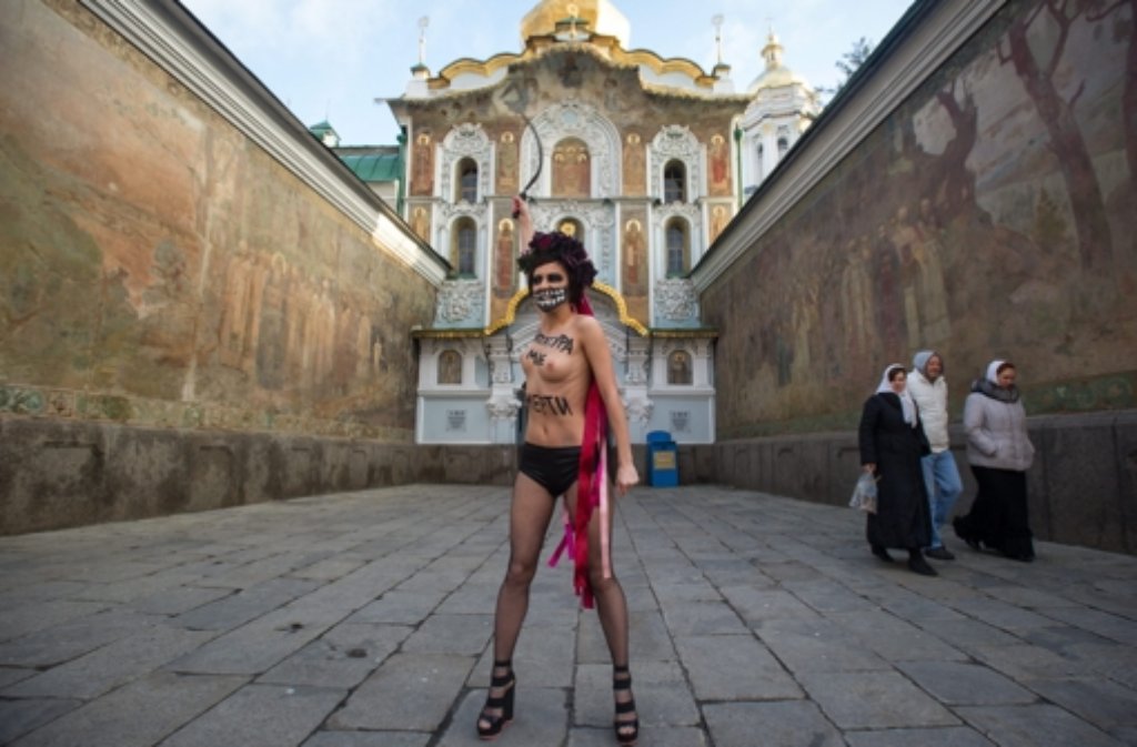 Trotz klirrender Kälte hat eine Femen-Aktivistin barbusig gegen Janukowitsch protestiert. „Tod der Diktatur“ stand auf ihrem Oberkörper.