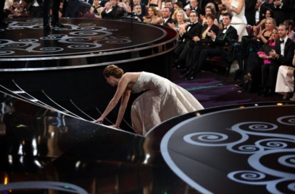 ... ihrem Oscar tückisch. Das opulente Kleid lässt die Schauspielerin stolpern.