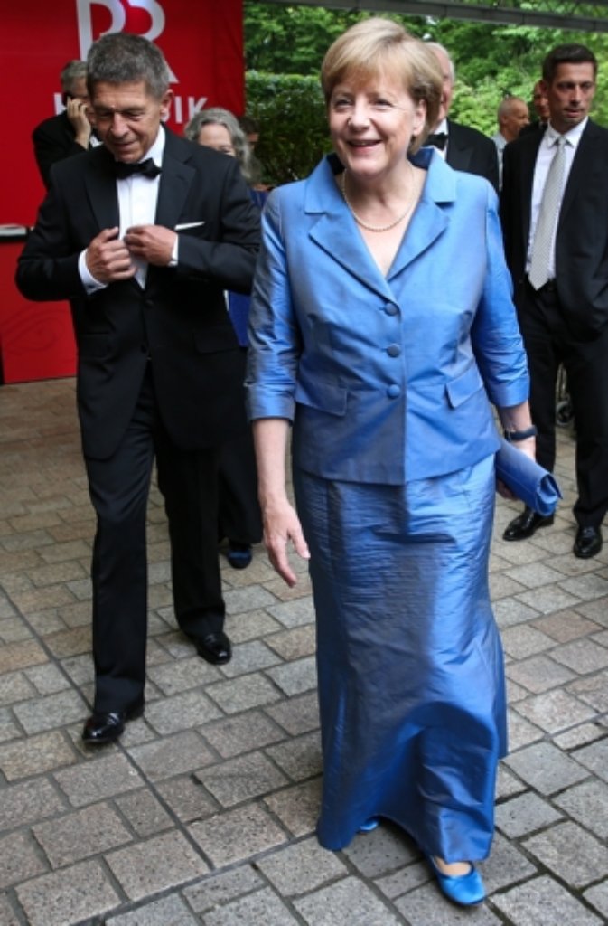 Die Kanzlerin trug das lange blaue Kleid mit farblich abgestimmten Accessoires, in dem man sie bereits im Vorjahr auf dem Grünen Hügel sah.