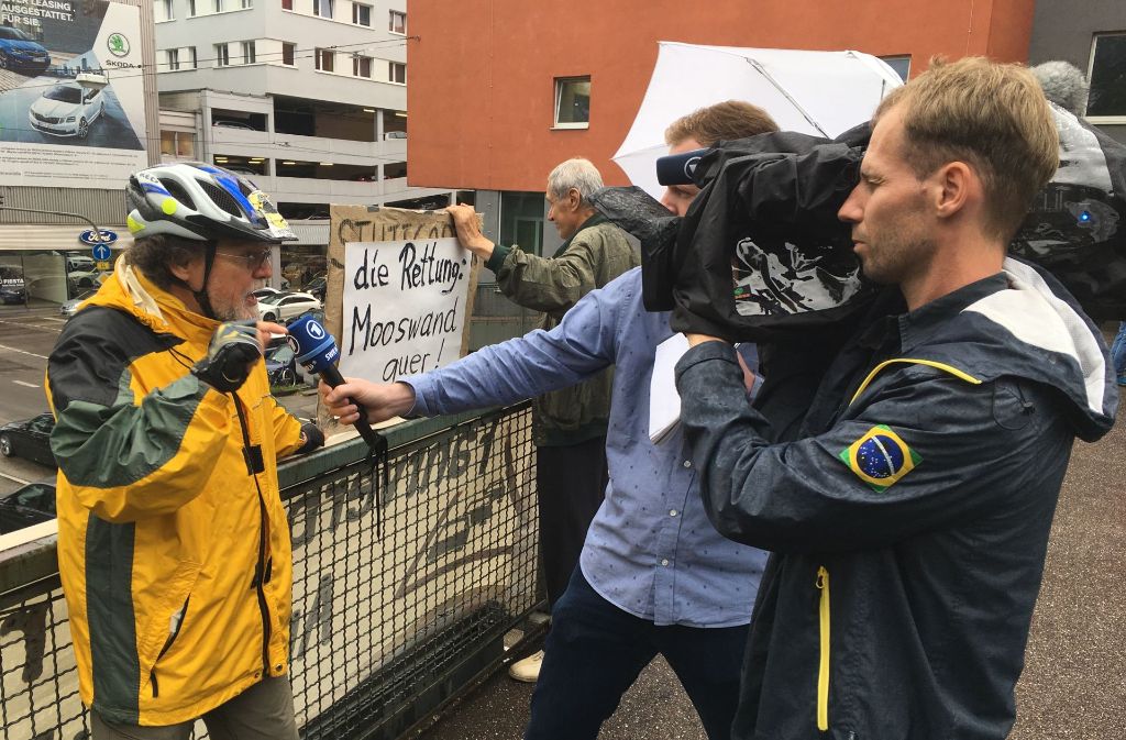 Ein ARD-Reporter interviewt Niess auf dem Fußgängersteg am Neckartor.