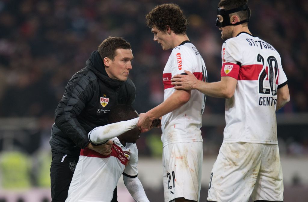 VfB-Coach Hannes Wolf, Benjamin Pavard und Christian Gentner kümmern sich nach Spielende um Chadrac Akolo.