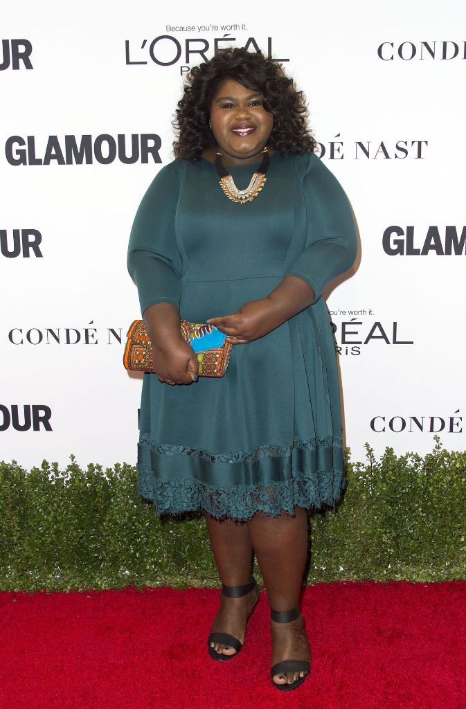 Schauspielerin Gabourey Sidibe entschied sich für ein blaugrünes Cocktailkleid mit Dreiviertelärmeln. Dazu kombinierte sie goldenen Schmuck und eine bunte Tasche.